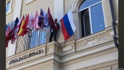 В Тбилиси активист сорвал флаг России со здания консерватории
